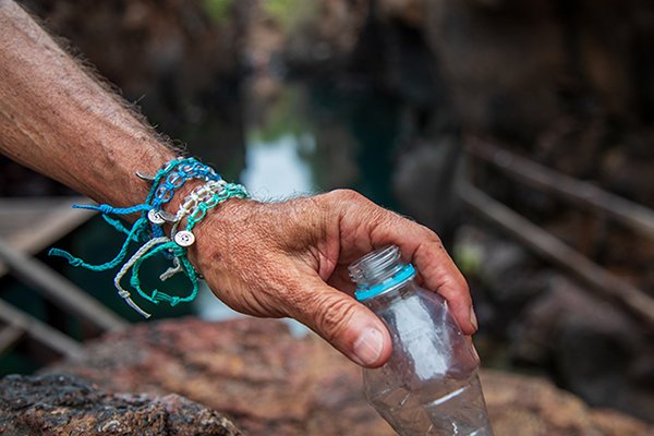 Wearing the bracelets while picking up a plastic bottle